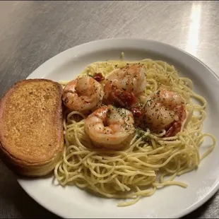 a plate of pasta with shrimp and bread