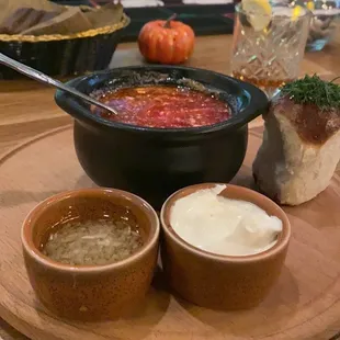 a bowl of soup and two bowls of dip