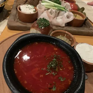 a bowl of soup with bread and dips