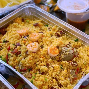 a tray of rice with shrimp and vegetables