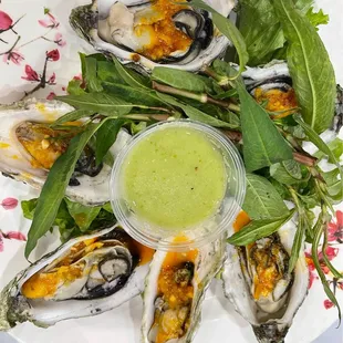 a plate of oysters with a side of sauce