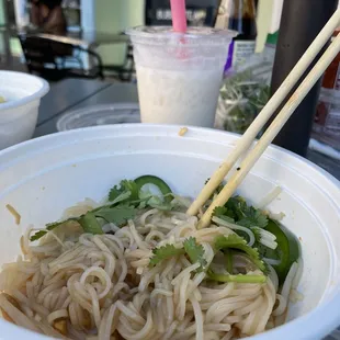 a bowl of noodles with chopsticks