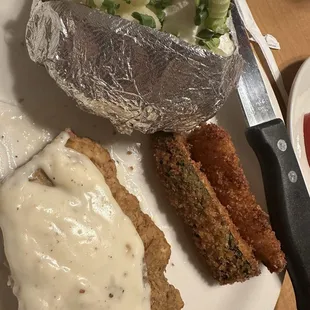 Chicken fried steak with zucchini, sticks and a baked potato
