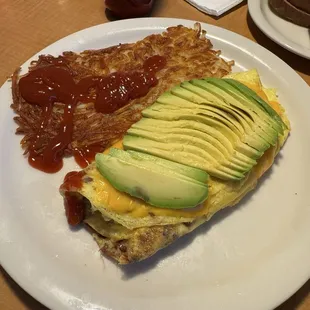 Bacon, avocado, and cheese omelette with an extra crispy hash brown