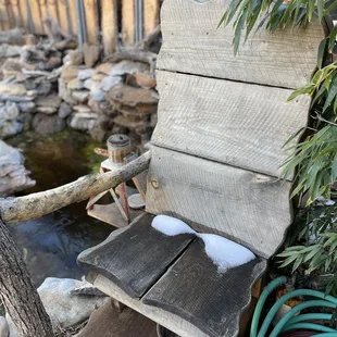 a wooden chair with snow on it