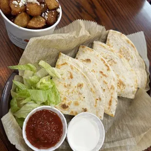Quesadila with a side of fried potatos.