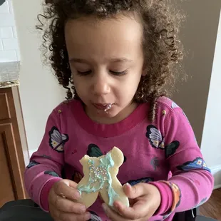 a little girl eating a cookie