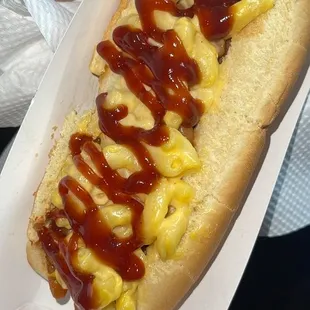 a person holding a hot dog with mustard and ketchup