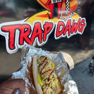 a hand holding a hot dog