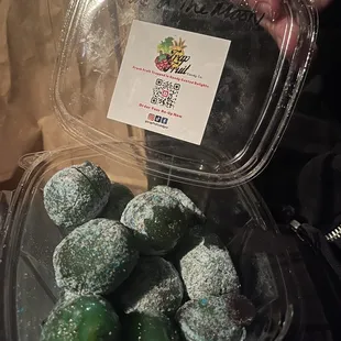 a person holding a plastic container filled with a variety of fruit