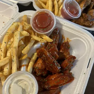 two trays of wings and french fries