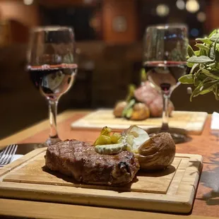 a steak and potatoes on a cutting board