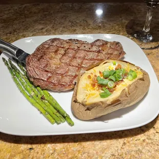Our 14 oz Ribeye with a loaded baked potato and asparagus.