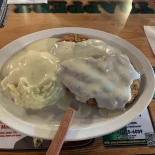 Country fried steaks 2 with mashed potatoes and gravy.