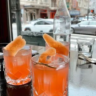 two glasses of orange juice on a table
