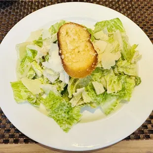 a plate of salad with a piece of bread