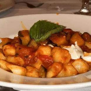 a plate of pasta with sauce and basil