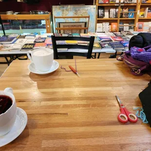 a cup of coffee and a pair of scissors on a table