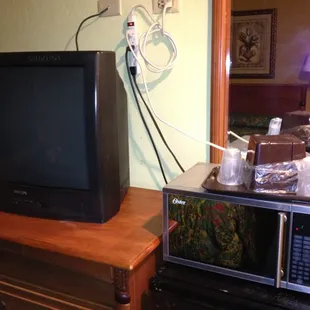 Tv, microwave and fridge daisy chained to the wall.