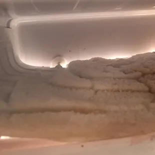 Yellow-brown built up old ice in freezer
