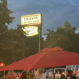 people sitting at tables under umbrellas