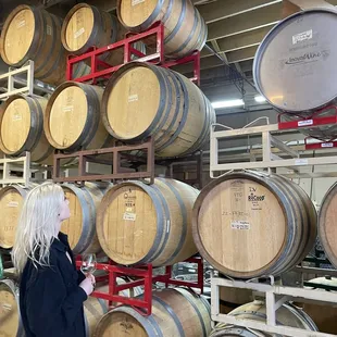 a woman standing in front of barrels
