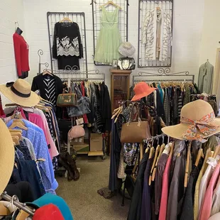 Clothing area with handbags, shoes, clothing in many sizes and hats.