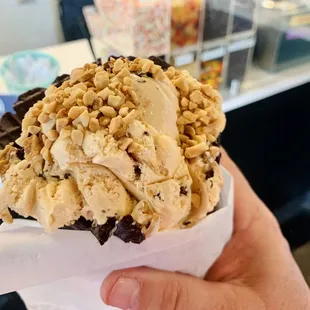 a hand holding a cone of ice cream