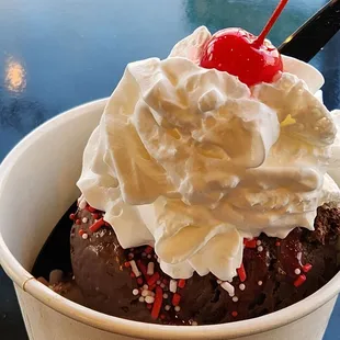 a chocolate sundae with whipped cream and a cherry on top