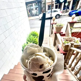 a hand holding a cup of ice cream