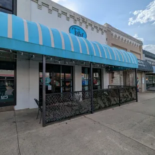 the outside of a restaurant with a blue awning