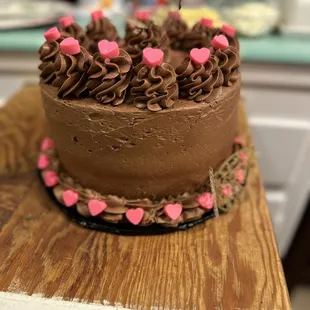 a chocolate cake with pink hearts