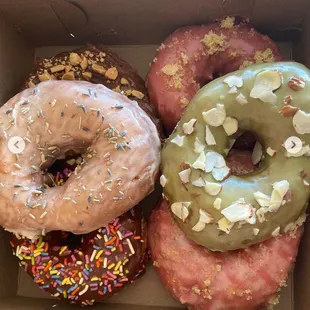 Donuts are (from bottom left) Turtle, chocolate sprinkles, Lavender, (bottom right)Berry Hibiscus, strawberry lemonade, and matcha almond.