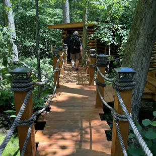 a man walking across a wooden bridge