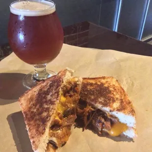 a grilled cheese sandwich and a glass of beer