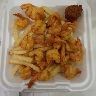 shrimp and fries in a styrofoam container