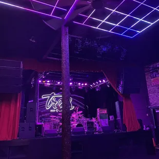 a stage with purple lights and red curtains