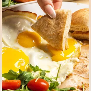 a person dipping an egg into a toaster