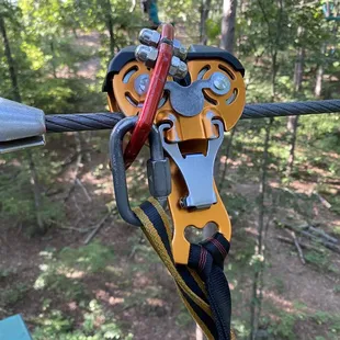 Orange zipline pulley and red hook