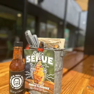 a hot sauce and a bottle of beer