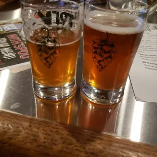 two glasses of beer on a bar