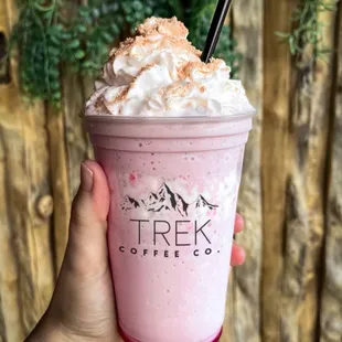 a hand holding a pink drink
