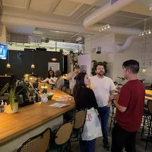 a group of people standing around a bar