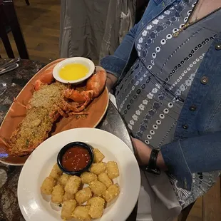 a woman sitting at a table with plates of food
