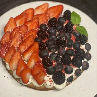 a cake with strawberries, blackberries, and blueberries