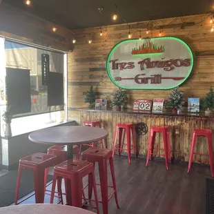 Inside - dining area has three tables and a small bar top.