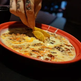 a person dipping a slice of lemon into a bowl of soup