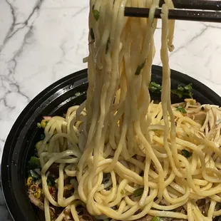 a bowl of noodles with chopsticks