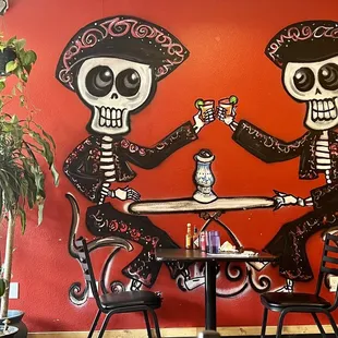 two skeletons sitting at a table