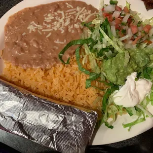 Refried beans, rice, tortillas in foil, with condiments for fajitas